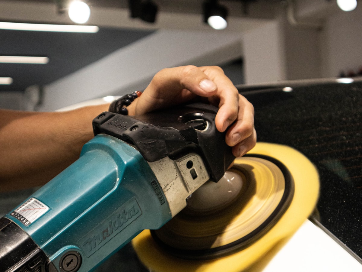 Orbital polisher bringing back the shine on a white car's paint