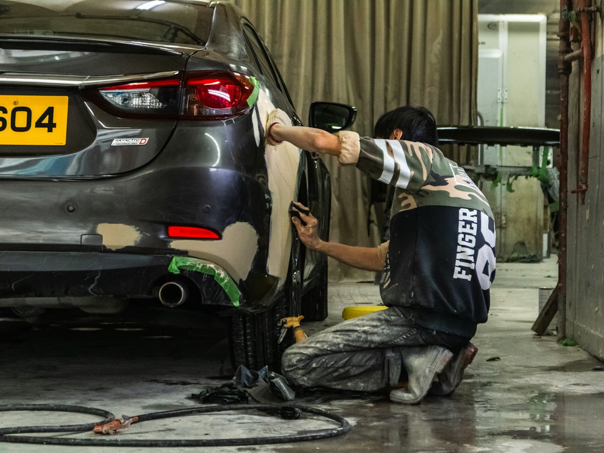Technician block-sanding a panel in preparation for paint