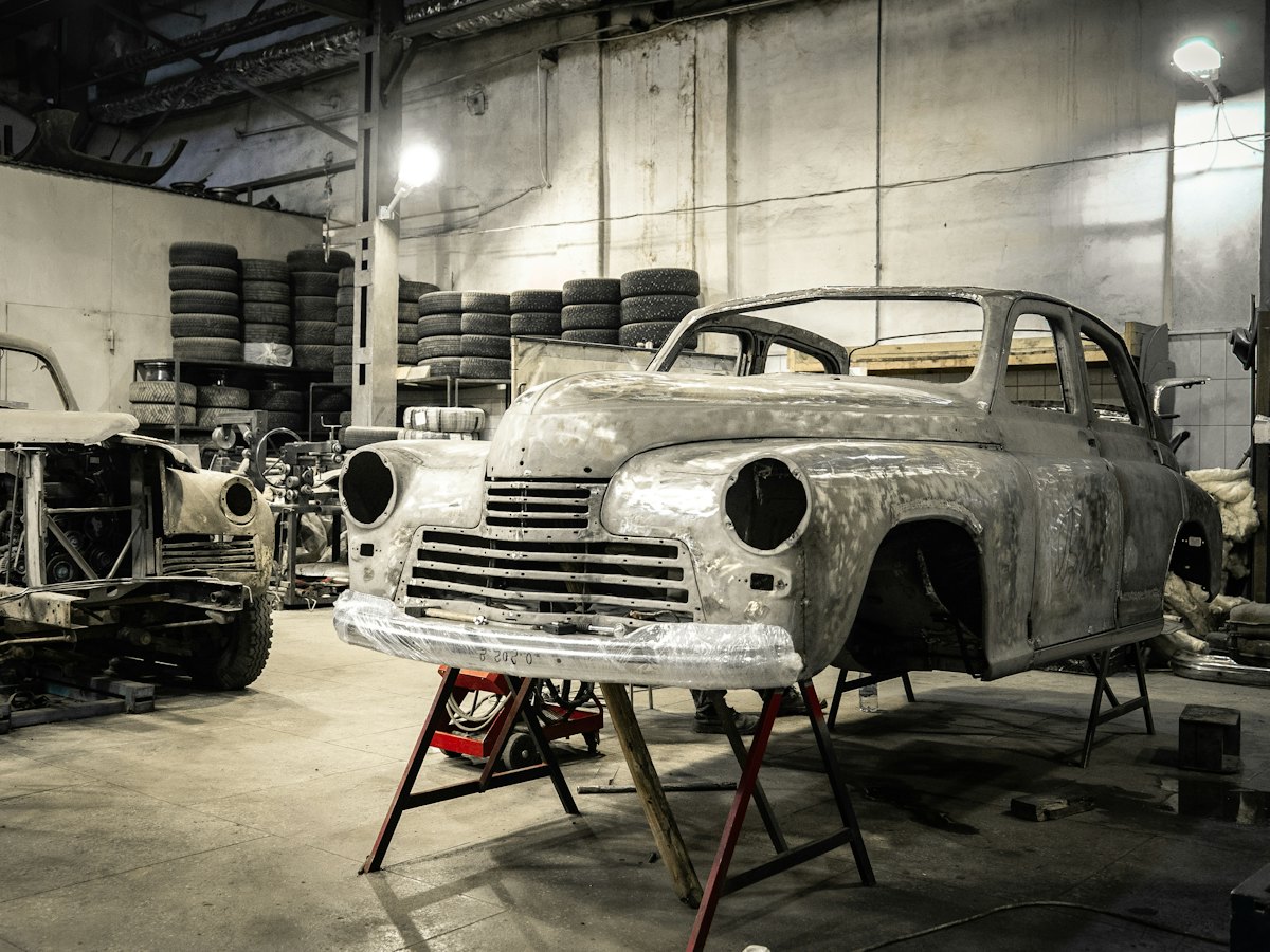 Classic car shell on stands mid-restoration in a body shop