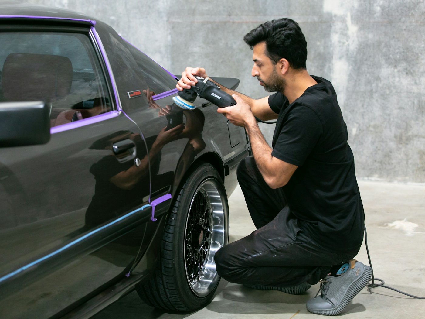 Detailer working on a car inside the shop